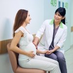 obstetrician for high-risk pregnancies speaking with her patient